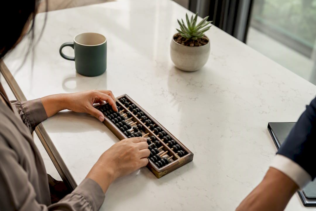 Hands manually calculating budget on vintage calculator