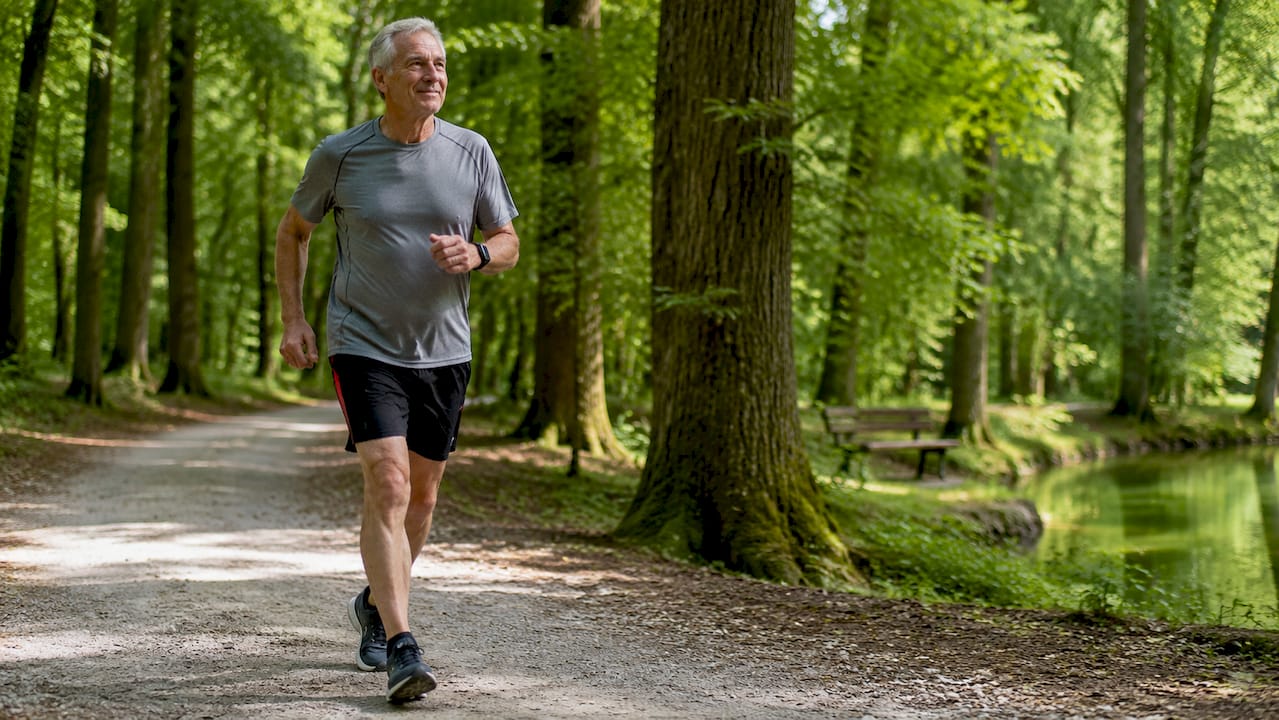 Senior man walking briskly in park