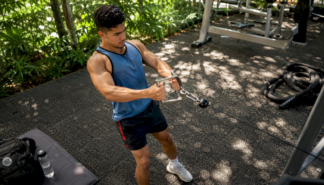 Man performing cable row exercise in gym