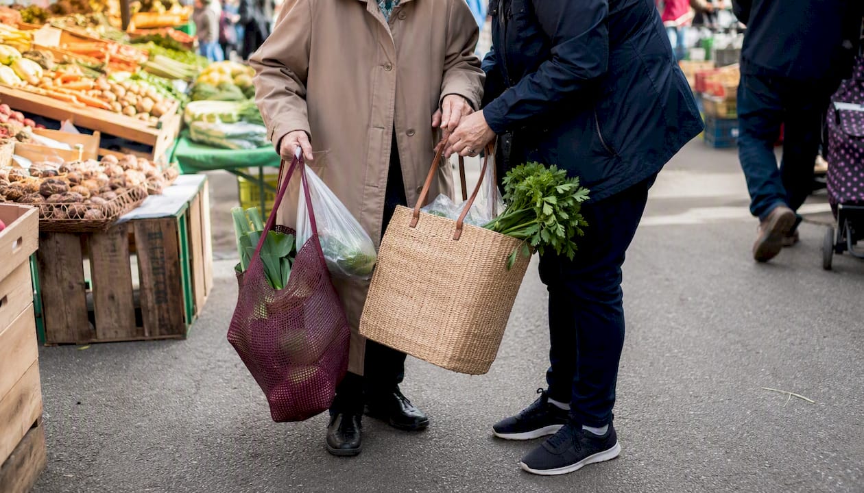 Hands holding grocery bags walking outside