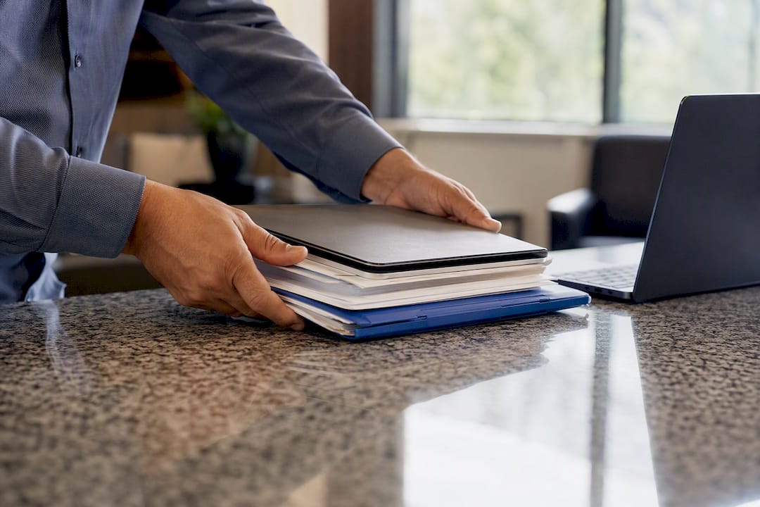 Hands aligning loan documents and tablet
