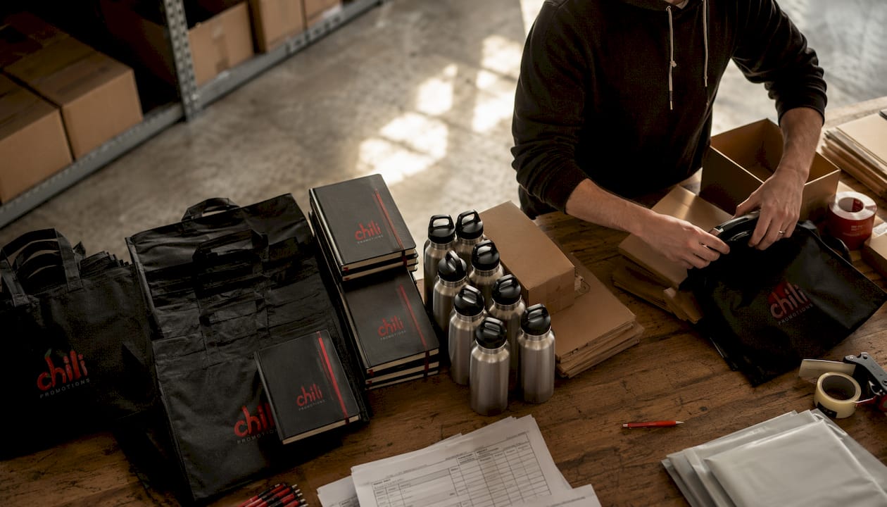 Hands packing consistent branded merchandise