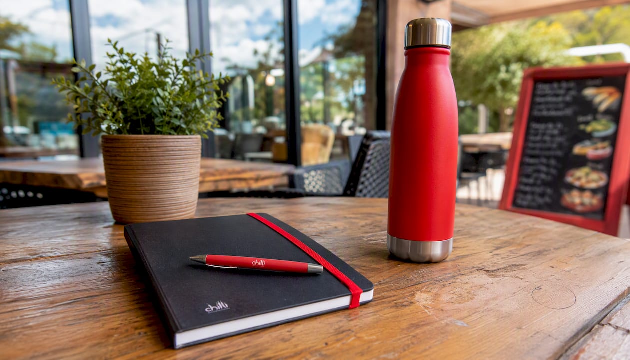 Branded promotional products on office desk with catalogs