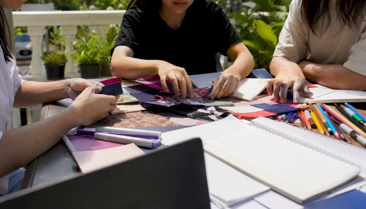 Student committee hands designing merchandise