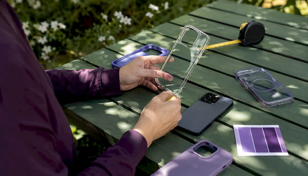 Hand comparing phone case materials overhead