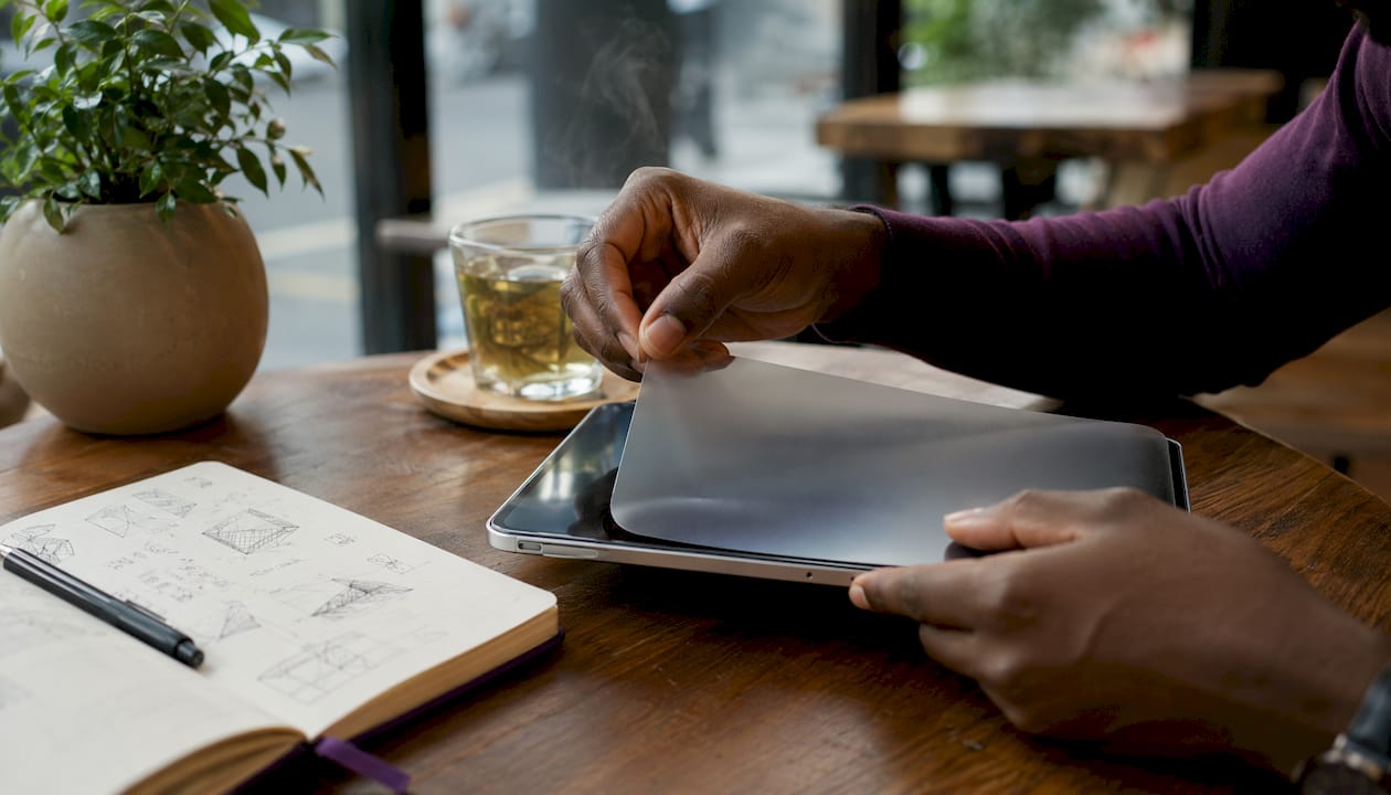 Hands applying matte adhesive film on tablet