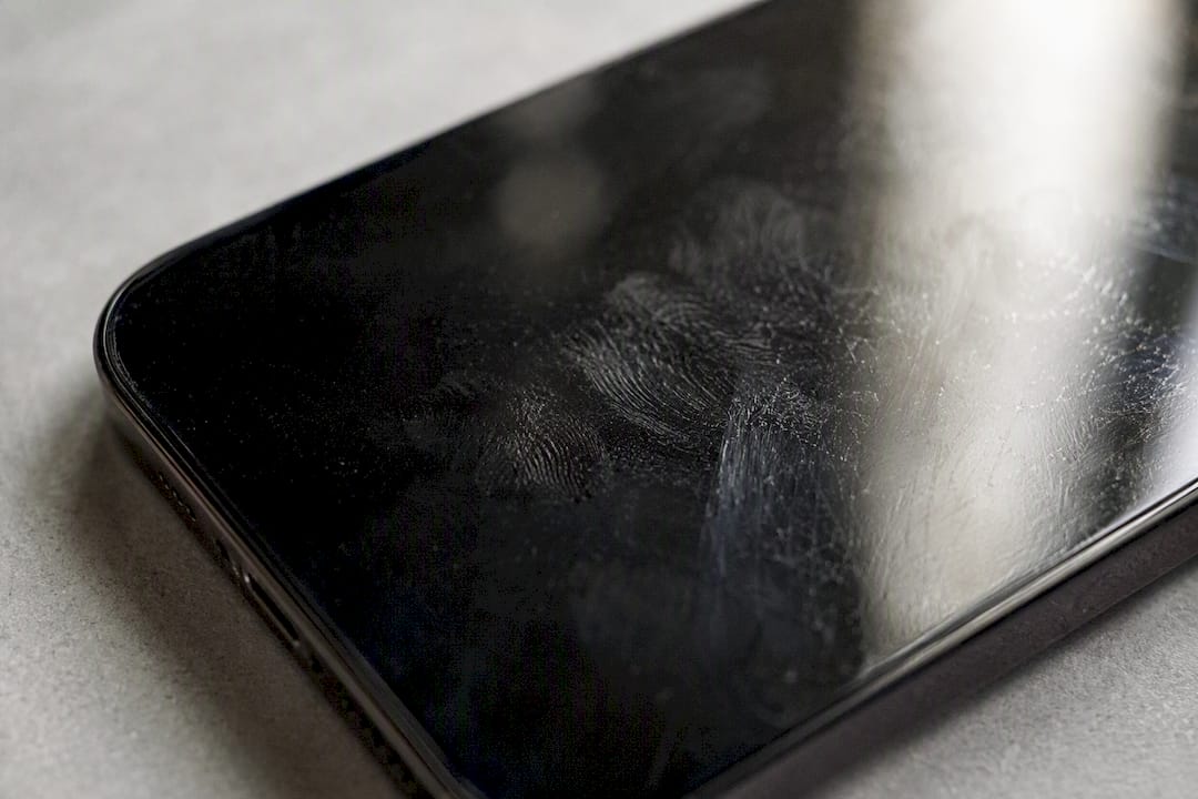 Close-up of smartphone screen with worn oleophobic coating