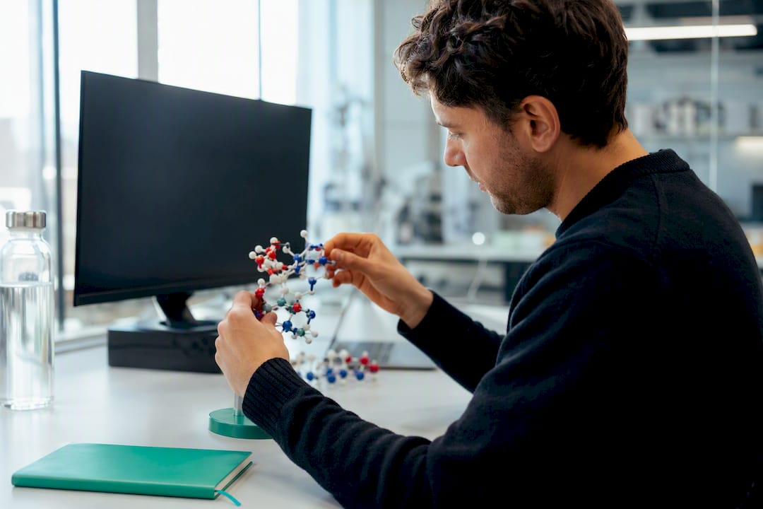 Scientist adjusting protein model in computational lab