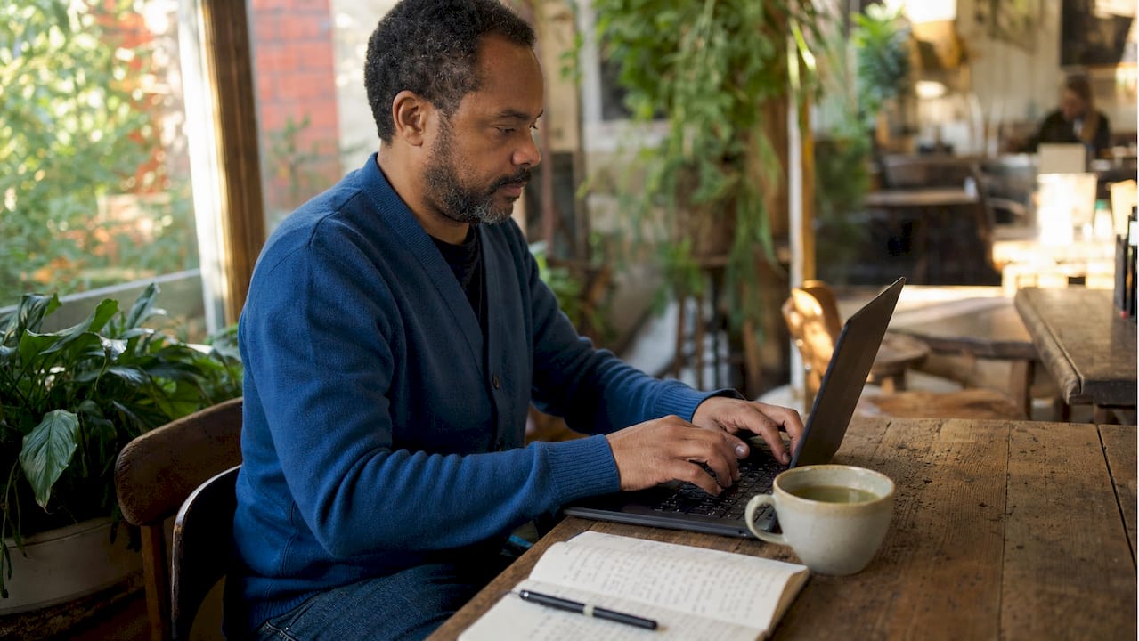 Hands typing on laptop editing business profile