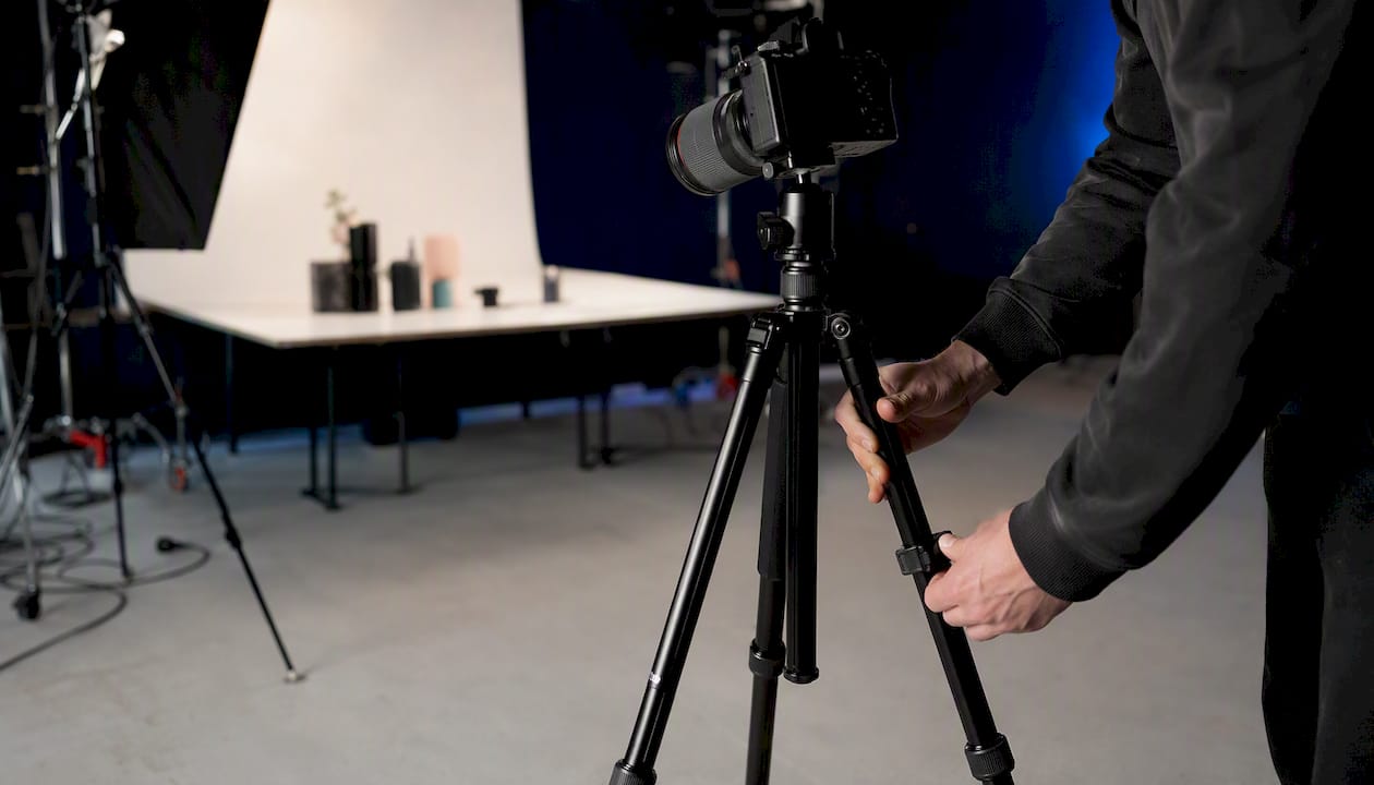 Hands adjusting camera in product image studio