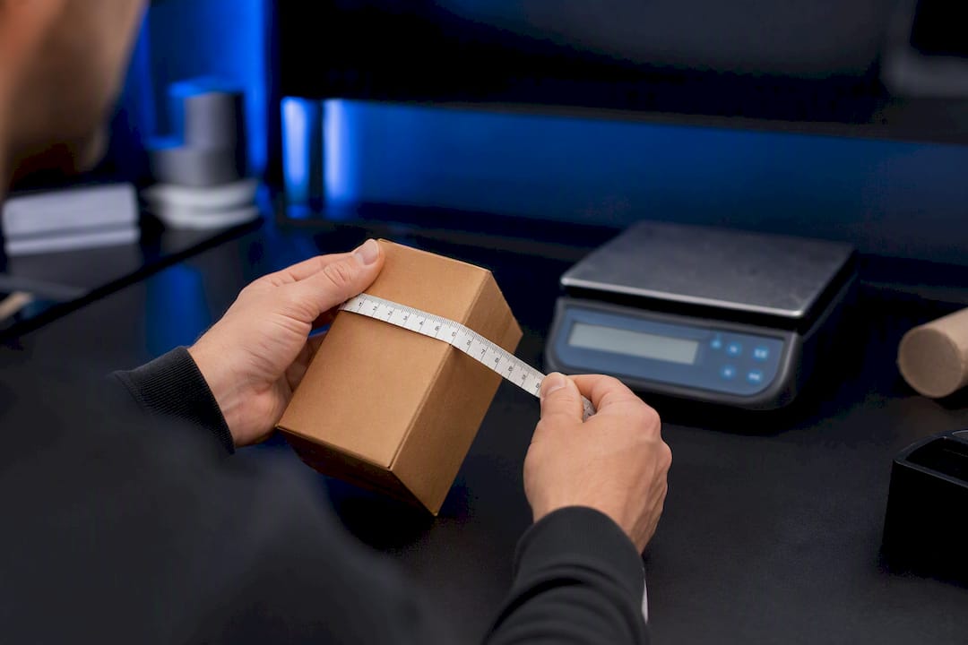 Hands measuring parcel size for FBA surcharge