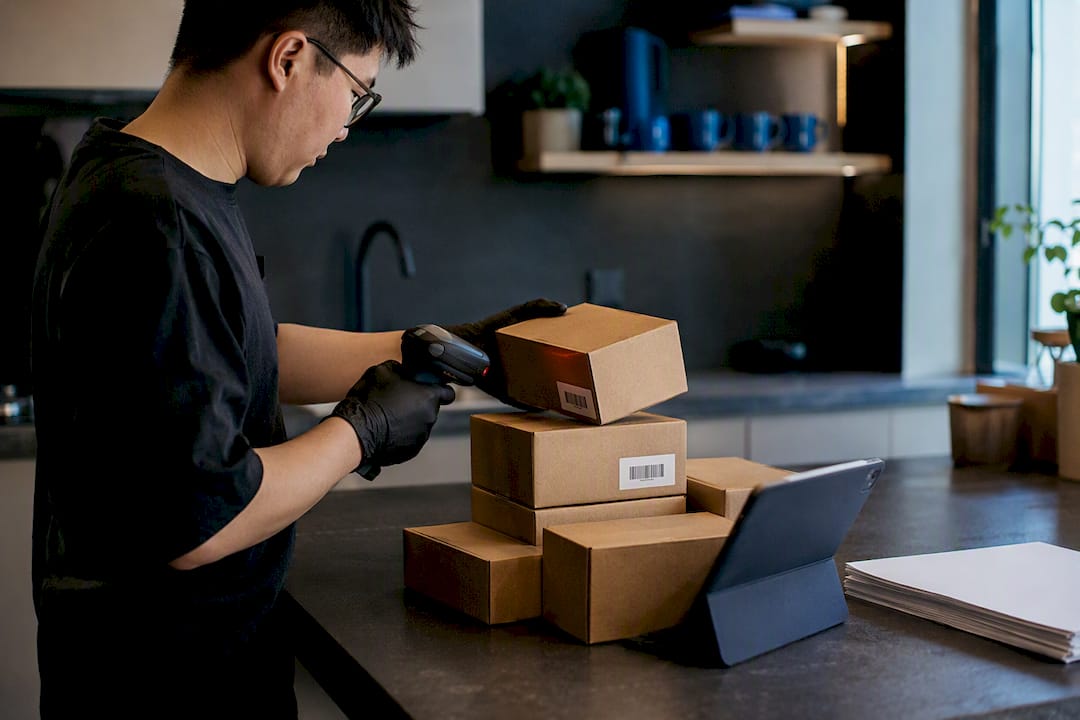 Hands scanning boxes in warehouse