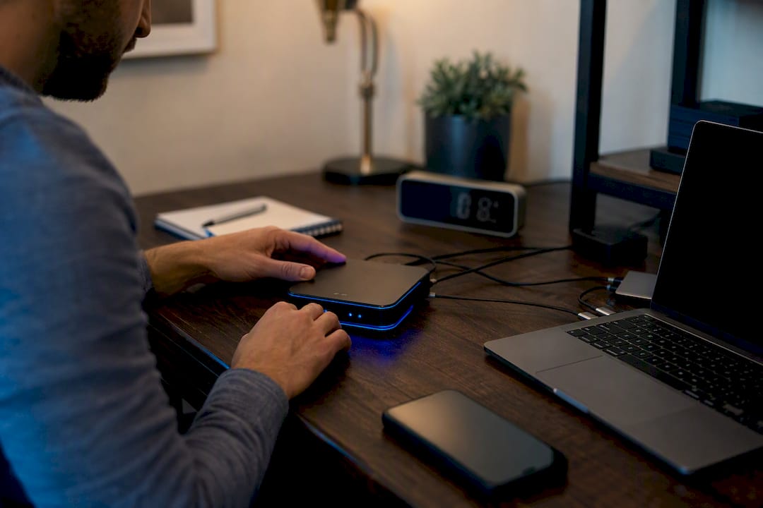 Hands adjusting glowing AI automation device