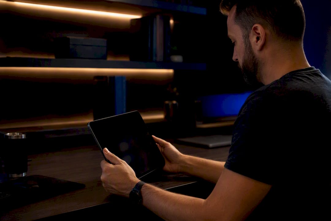 Hands ready to activate automation on dark tablet