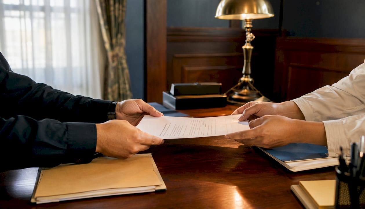 Close-up hands exchanging bail bond contract