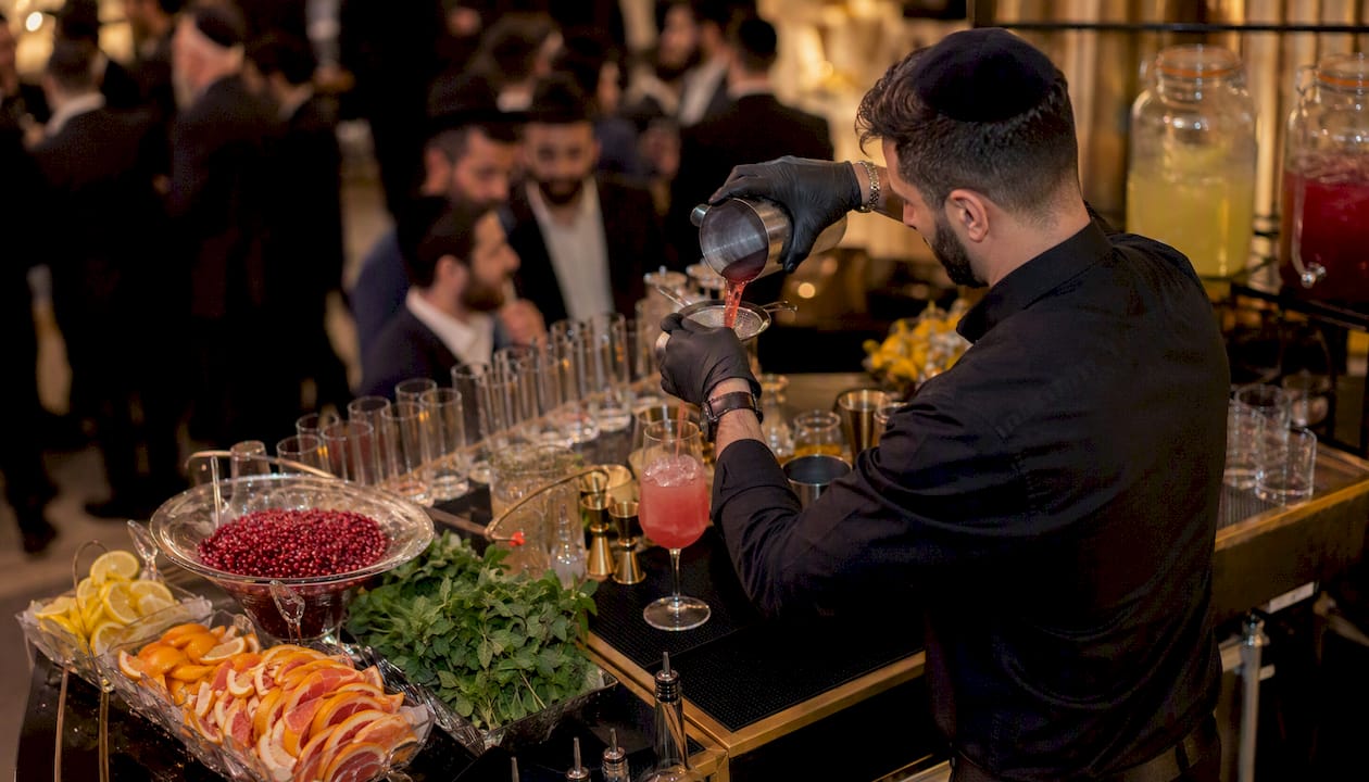 Bartender pouring fruit mocktail at event bar