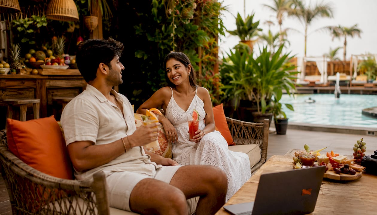Couple enjoying cocktails at luxury hotel poolside