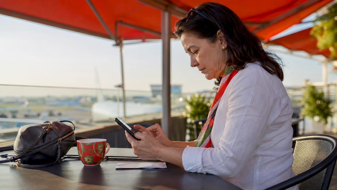 Hands checking roaming day pass costs on smartphone