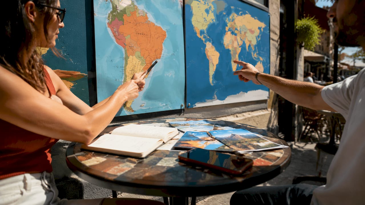 Hands comparing regional and global eSIM maps