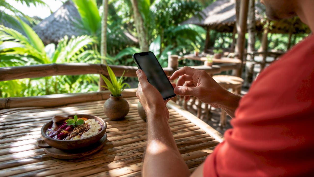 Traveller activating eSIM on smartphone in Bali café