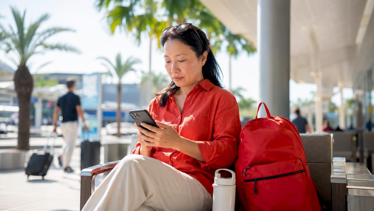 Traveler activating eSIM on phone at airport café
