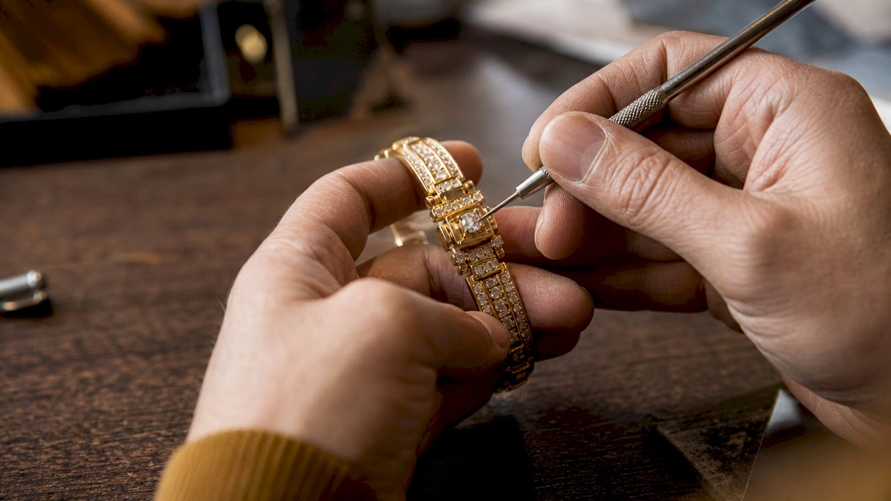 Close-up of hands inspecting jewelry clasp and prongs
