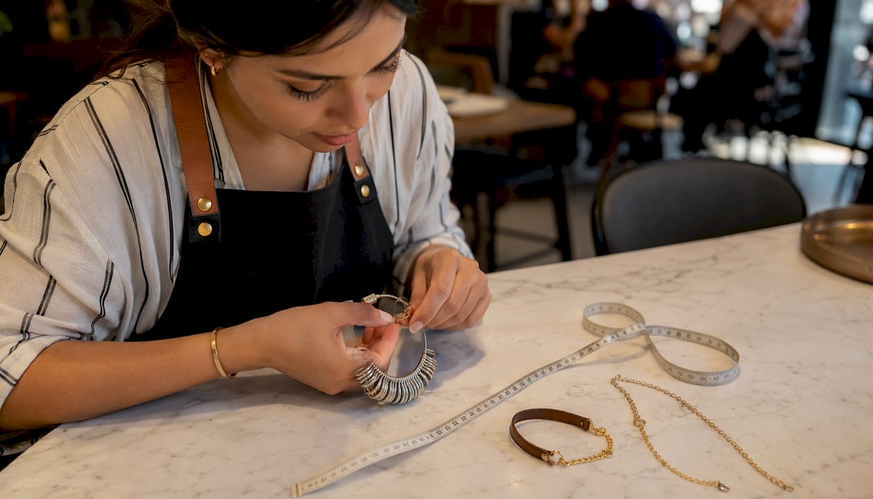 Jeweler accurately measuring ring size on workbench