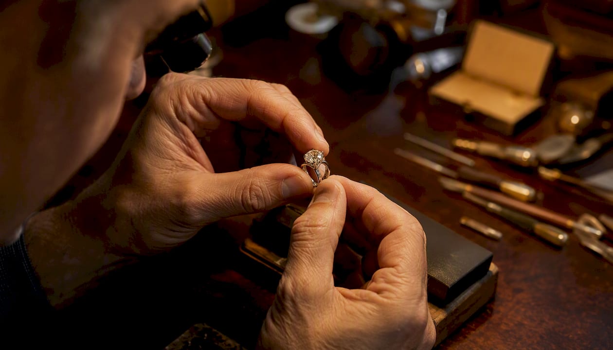 Hands placing diamond into new ring setting