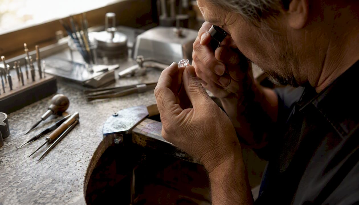 Jeweler examining diamond girdle with loupe