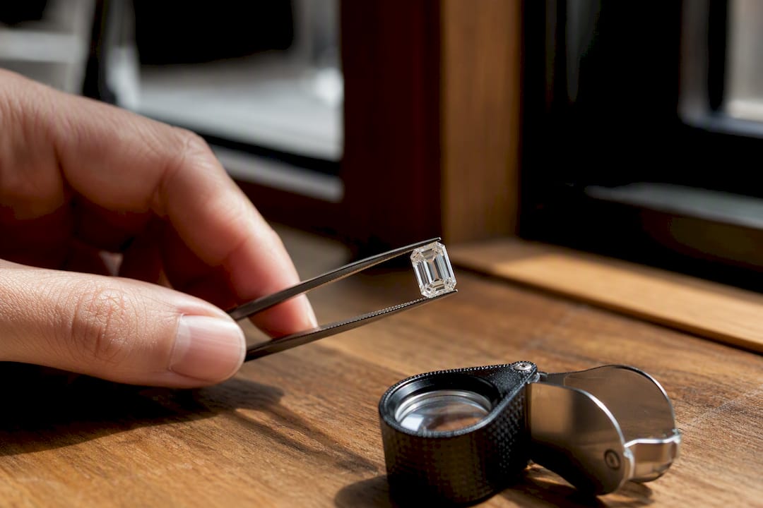 Close-up of step-cut diamond in tweezers