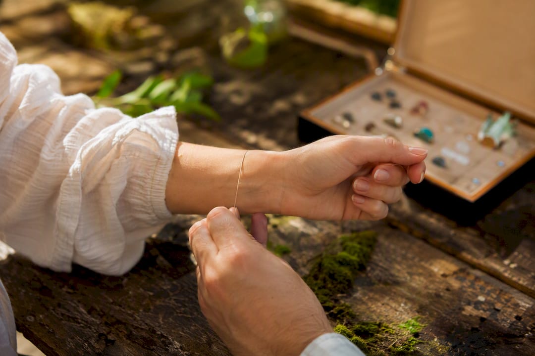 Hands measuring wrist with string for gift sizing