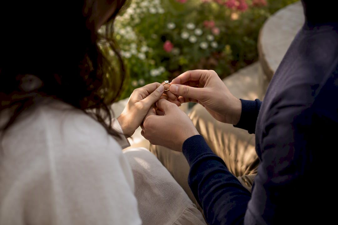 Couple examining diamond ring outdoors