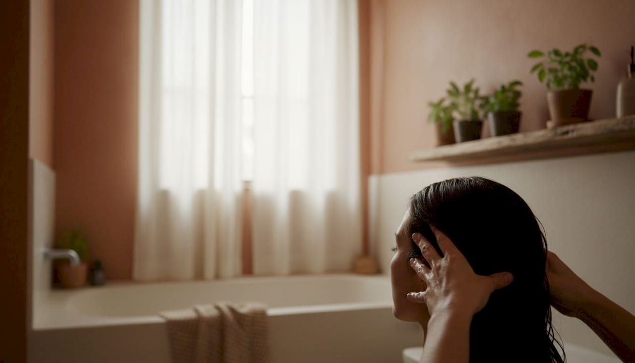 Hands massaging scalp with rosemary oil