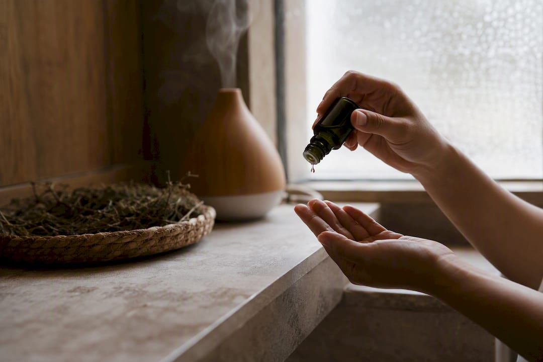Hands pouring facial oil drops on fingertip
