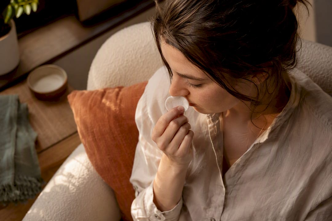 Person practicing calming aromatherapy inhalation