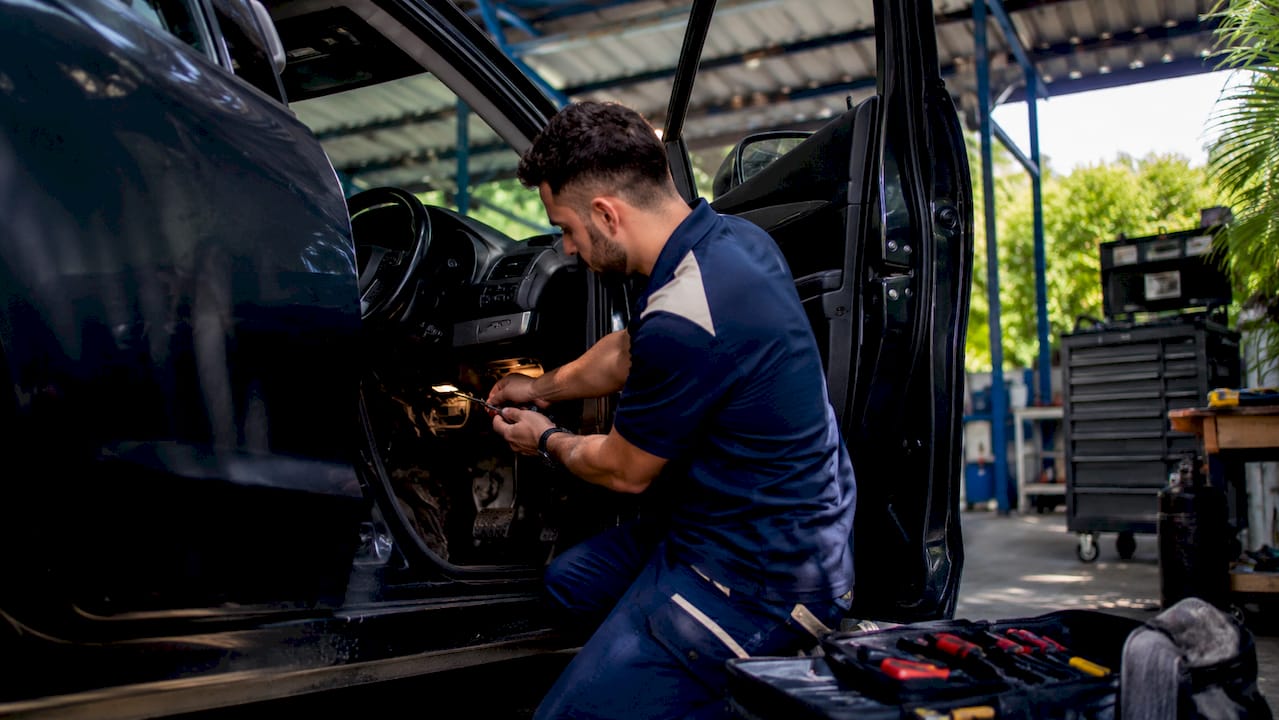 Hands installing Thatcham-approved tracker