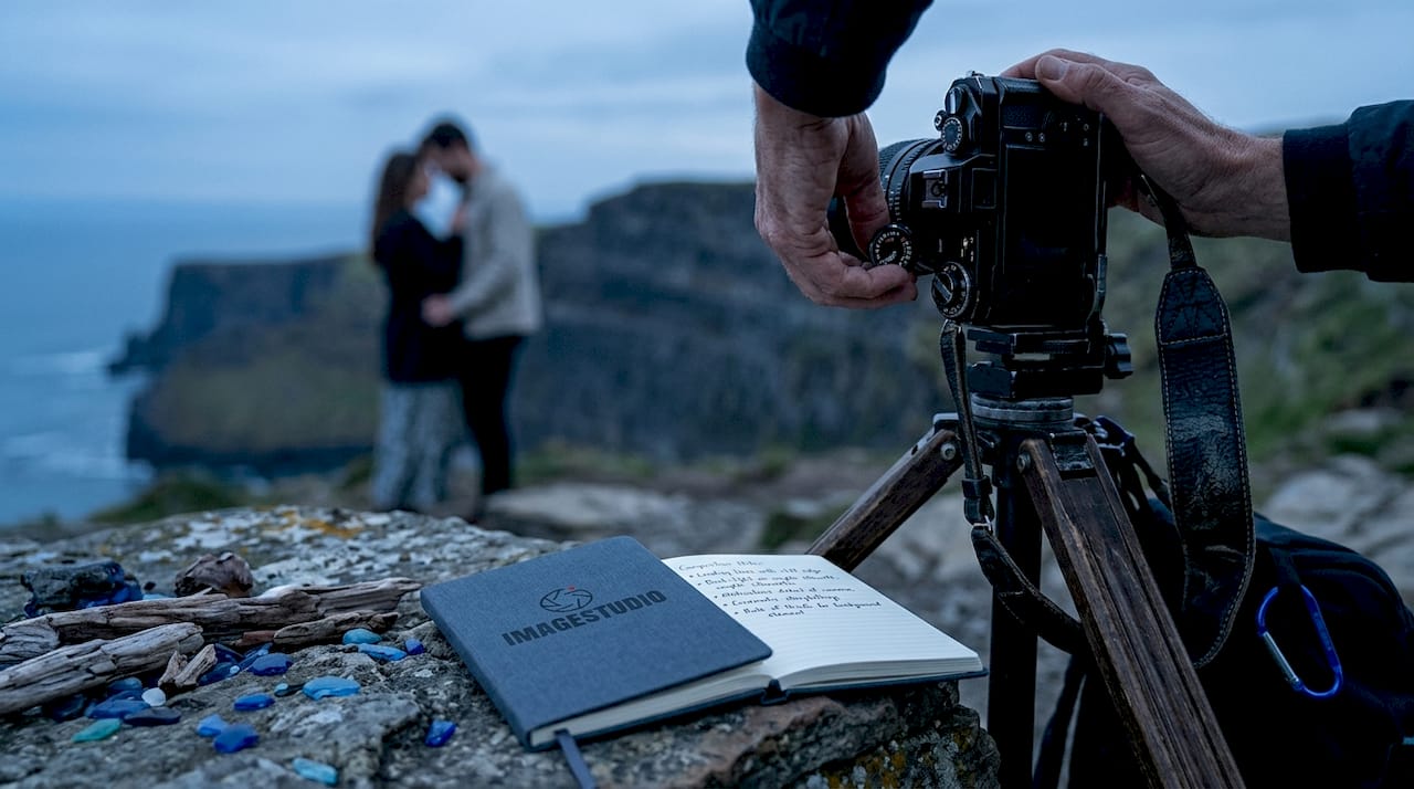 Photographer preparing camera on beach at sunset