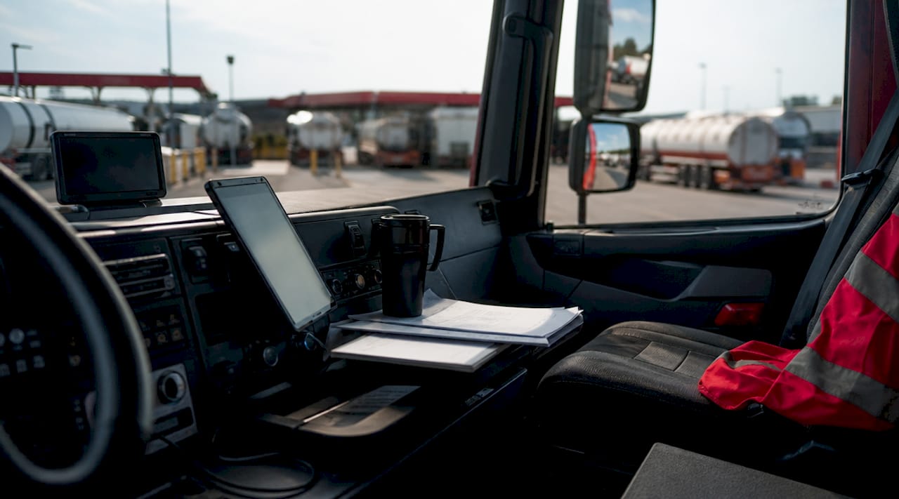 The Role of Technology in Fuel Delivery Operations 1 Fuel delivery driver using route tablet inside truck cabin