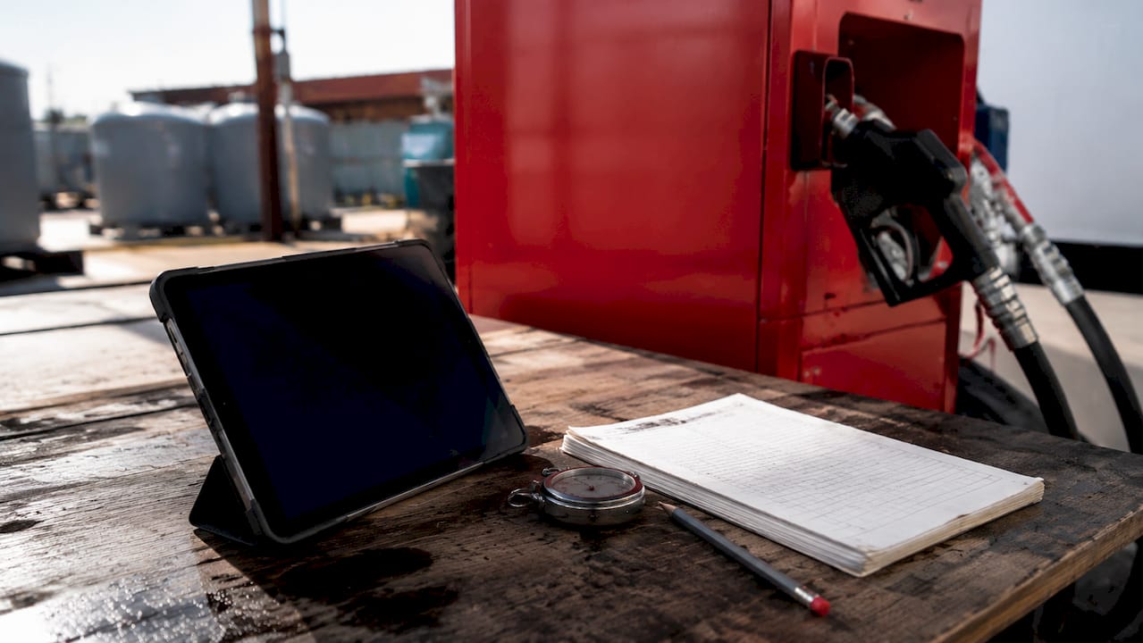 Why Utilities Need Contracted Diesel Delivery in 2026 1 Hands at utility fueling station with digital tablet and logbook