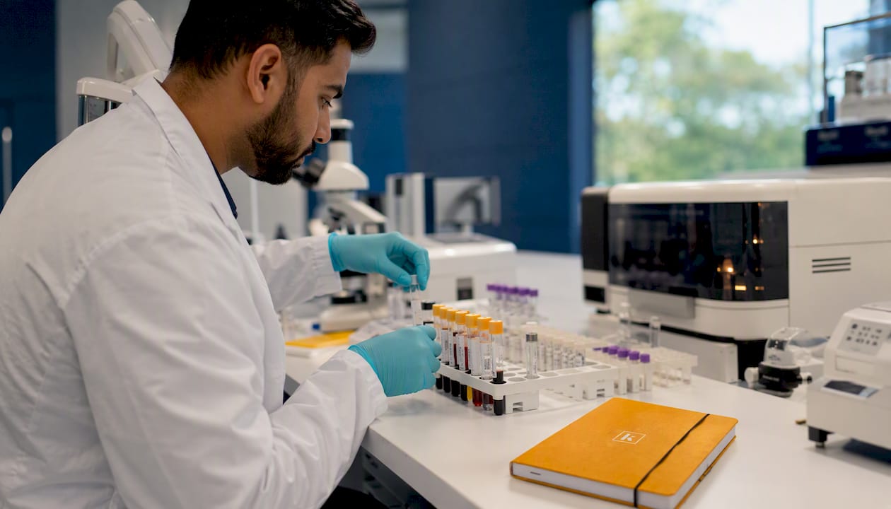 Technician handling test tubes in clinical lab