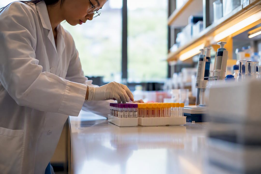 Technician handling diagnostic sample tubes in lab