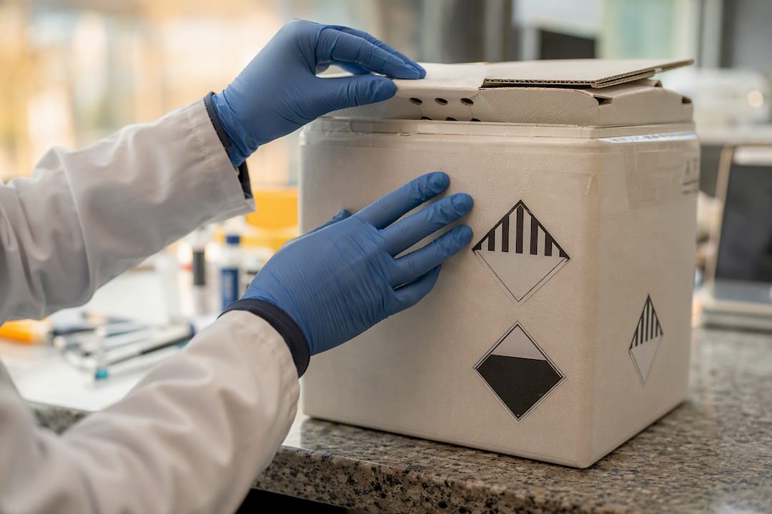 Hands inspecting dry ice shipment box and venting