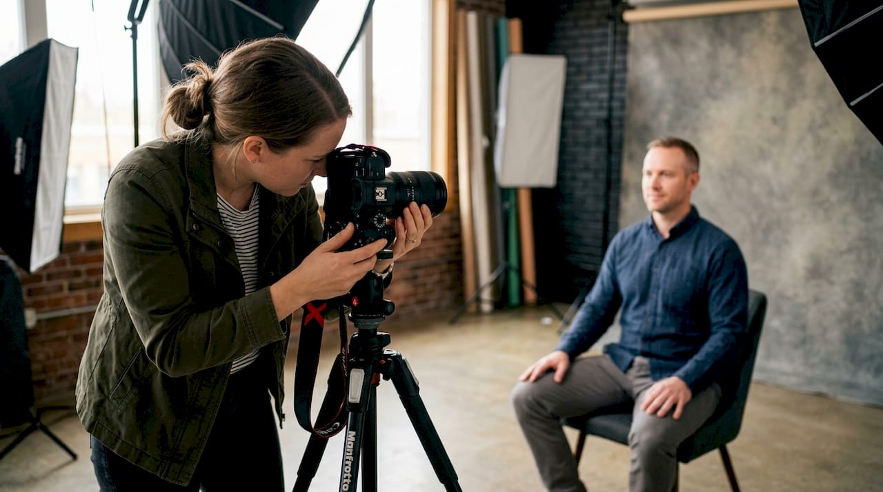 Photographer adjusting camera settings in studio