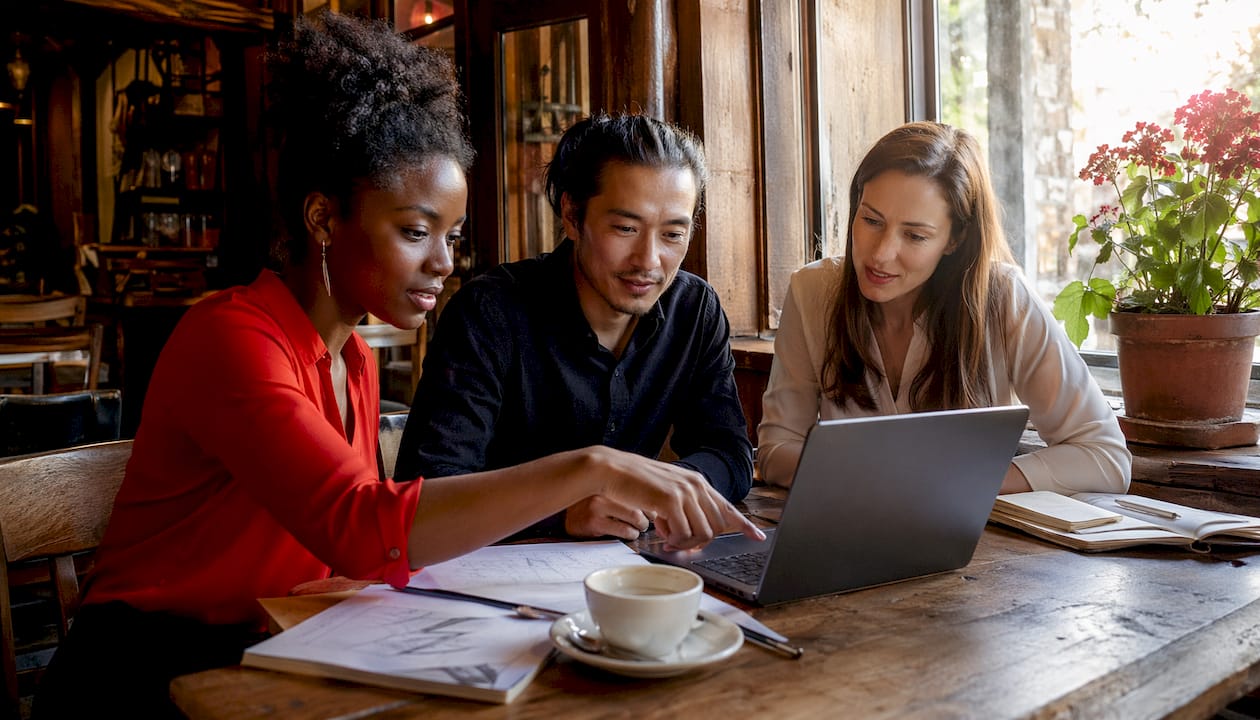 Employees collaborating candidly in workspace