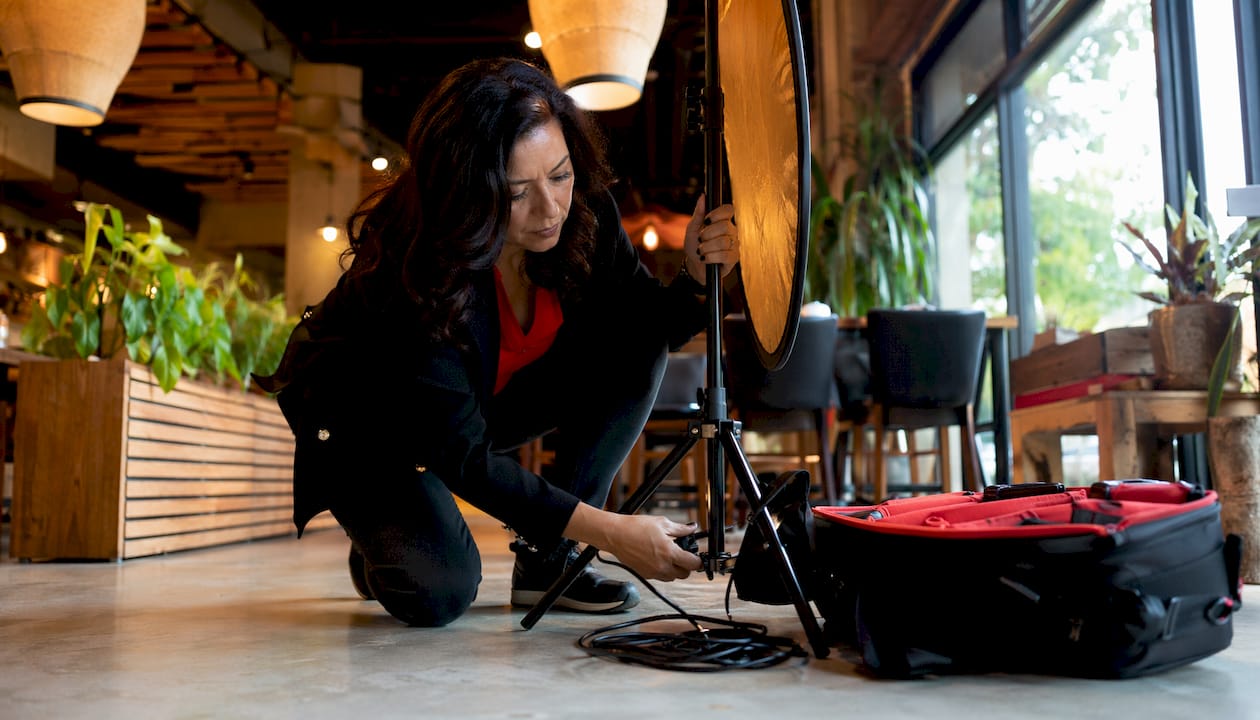 Photographer setting portable lighting in corporate studio