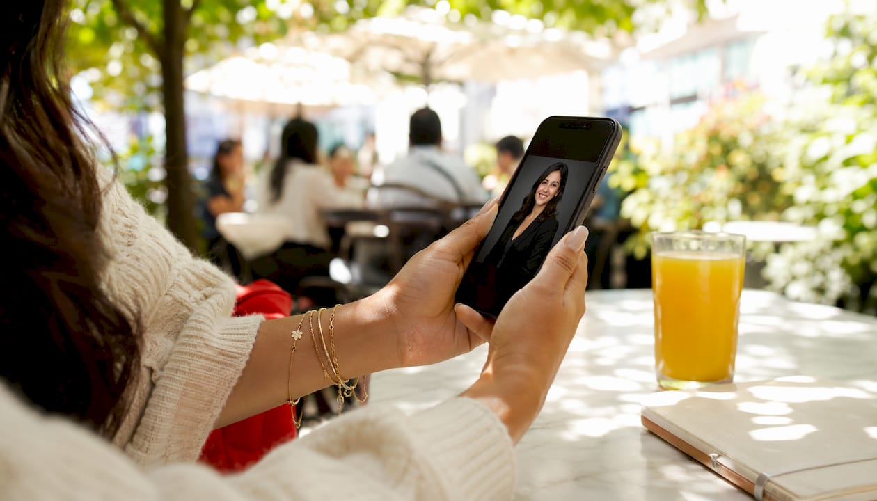 Hands holding smartphone reviewing headshot