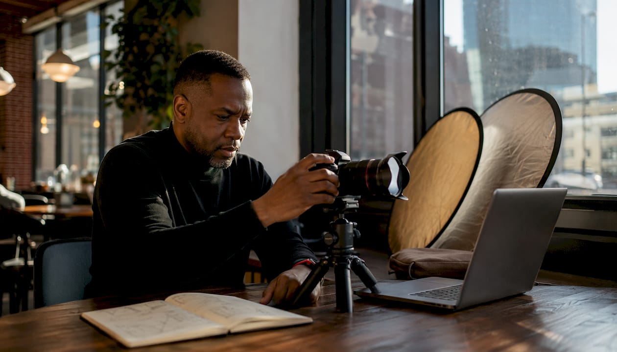 Photographer adjusting camera settings indoors