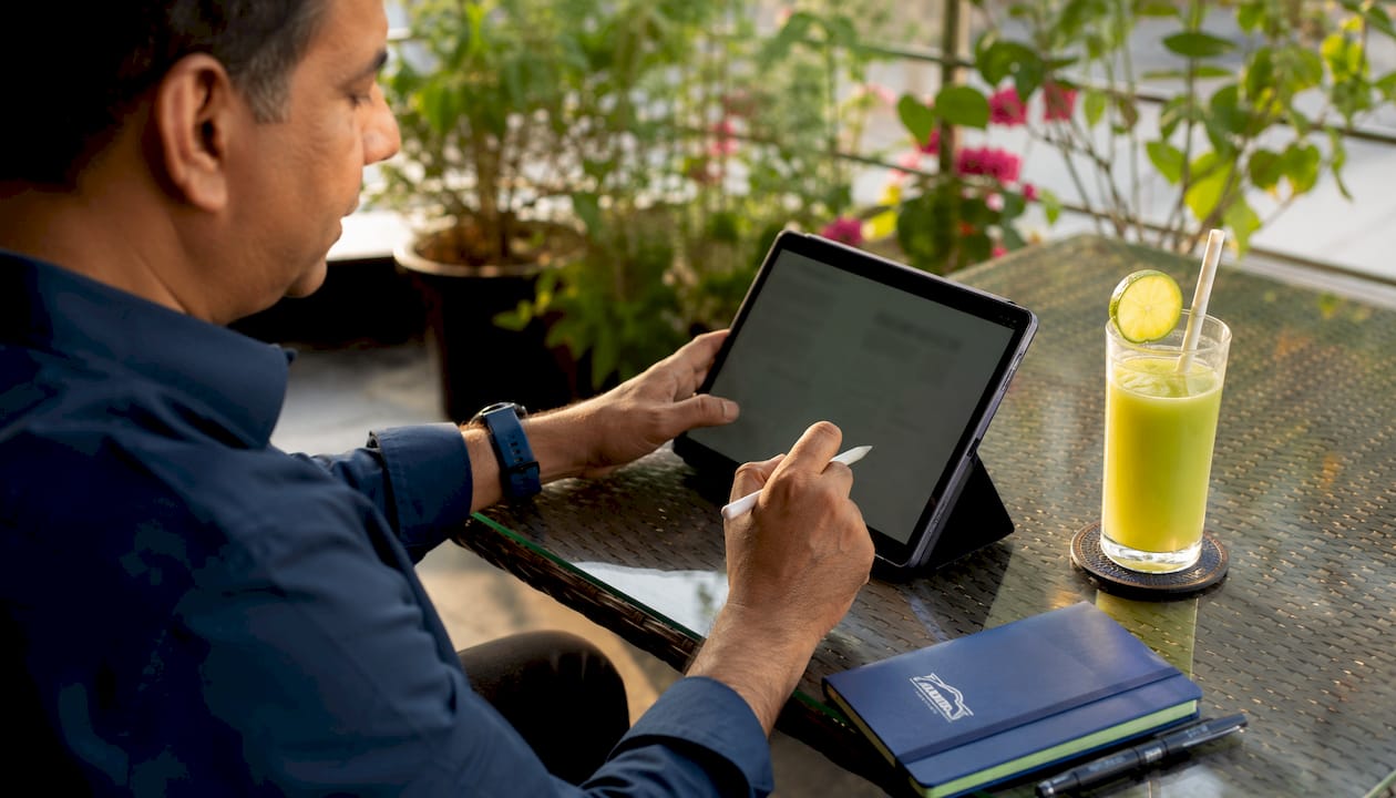 Hands making notes on tablet with electric car brochure