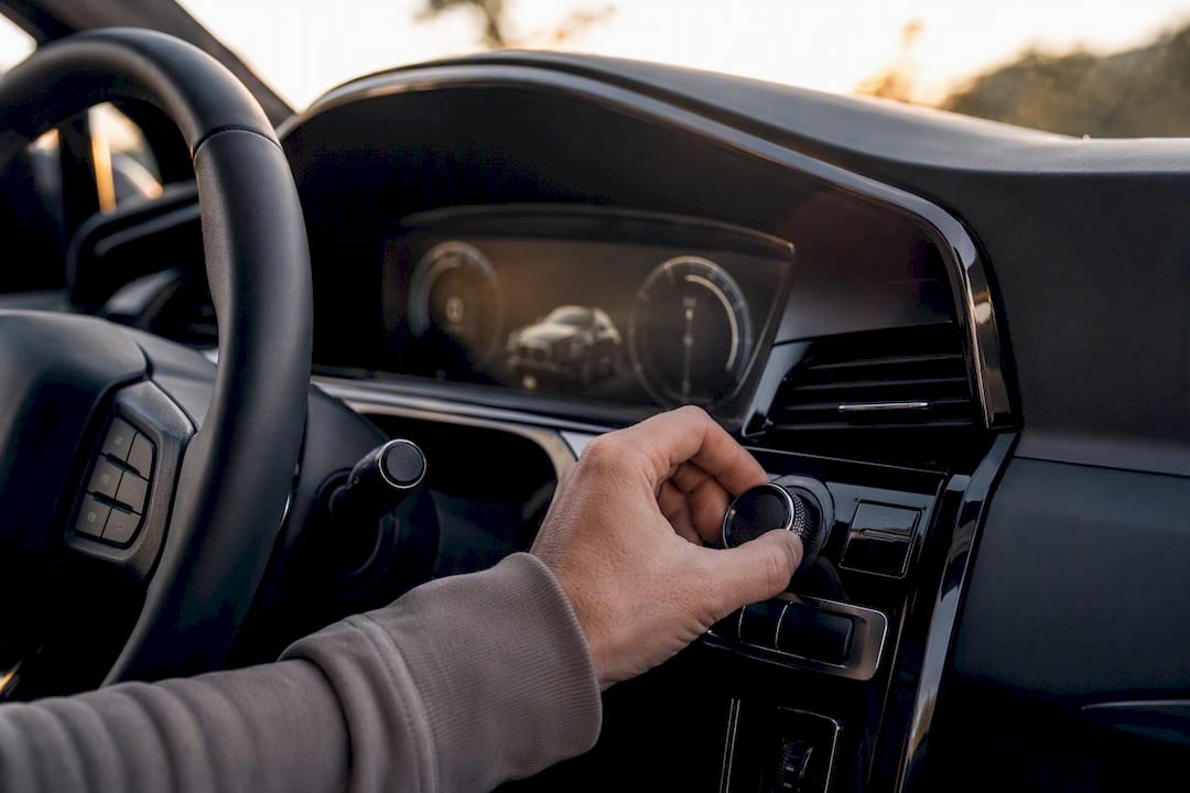 Hand adjusting vehicle mileage settings inside car