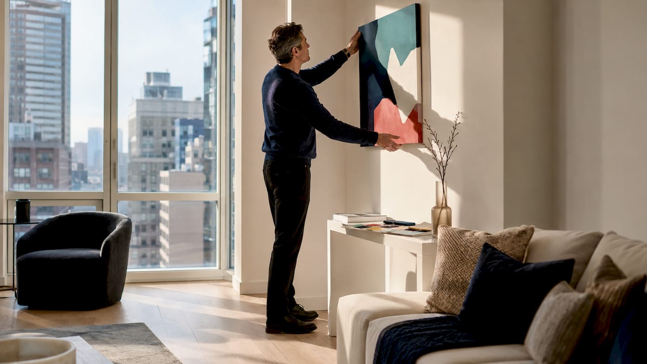 Man positioning statement wall art at home office